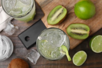 Glasses of refreshing drink with kiwi on table, flat lay