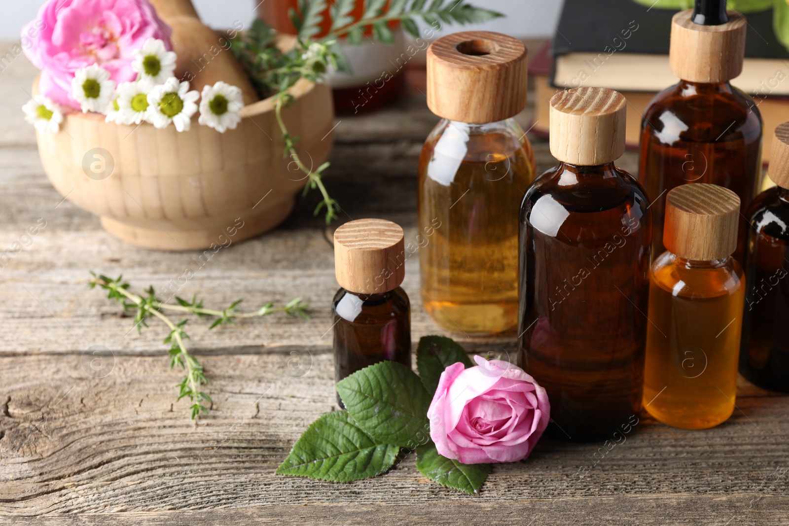 Photo of Aromatherapy. Different essential oils and flowers on wooden table