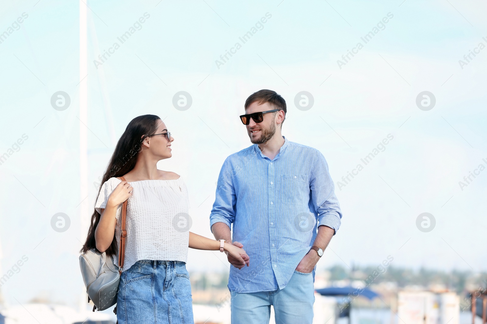 Photo of Young hipster couple in jean clothes on pier