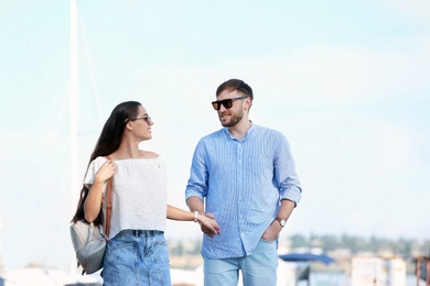 Photo of Young hipster couple in jean clothes on pier