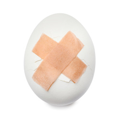 Photo of Cracked egg with sticking plasters isolated on white, top view