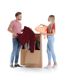 Young couple near wardrobe boxes on white background