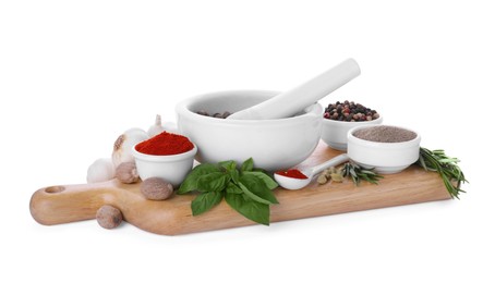 Photo of Mortar with pestle and different spices on white background