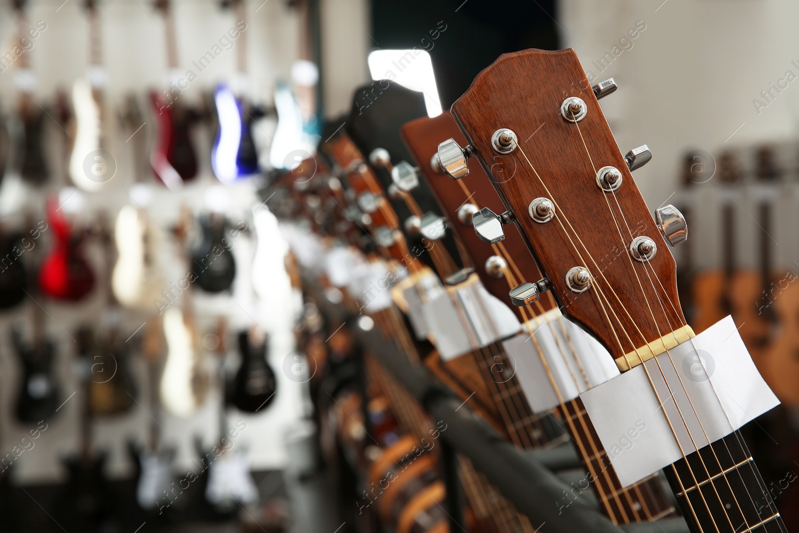 Photo of Row of different guitars in music store, closeup