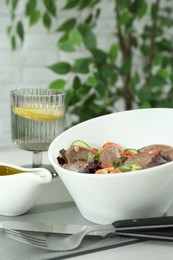 Delicious salad with beef tongue and vegetables served on table. Space for text