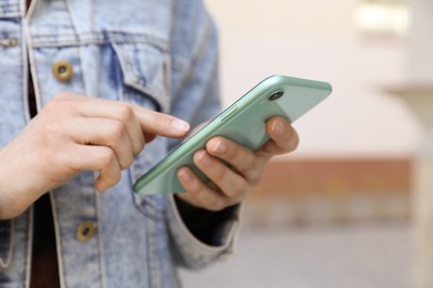 Photo of Closeup view of woman using smartphone outdoors