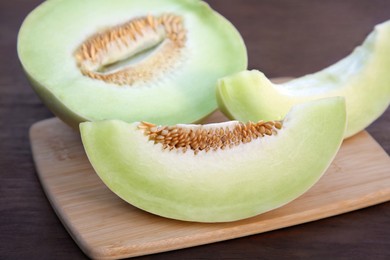 Photo of Cut tasty ripe melon on wooden table