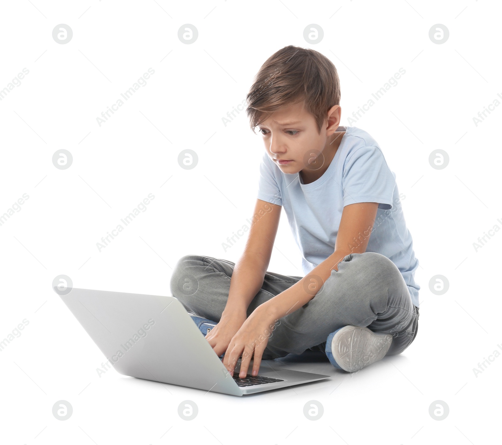 Photo of Shocked child with laptop on white background. Danger of internet