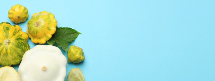 Image of Fresh pattypan squashes on light blue background, flat lay with space for text. Banner design