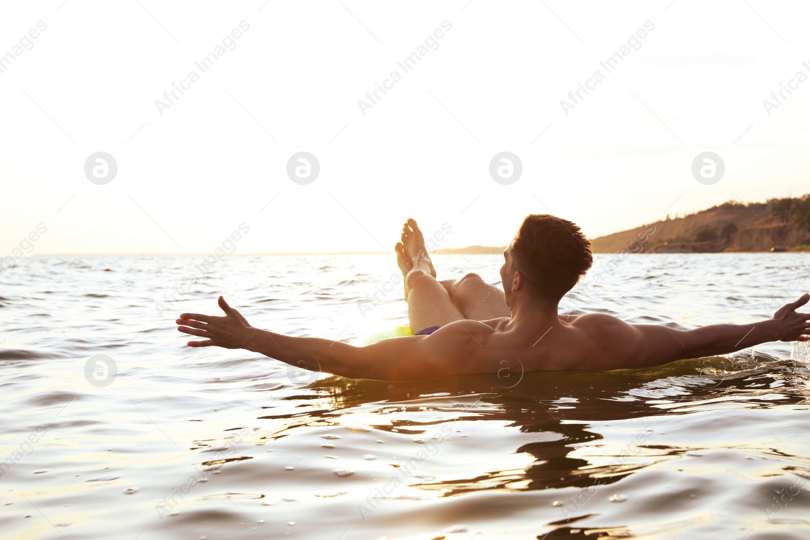 Photo of Young man with inflatable ring in sea