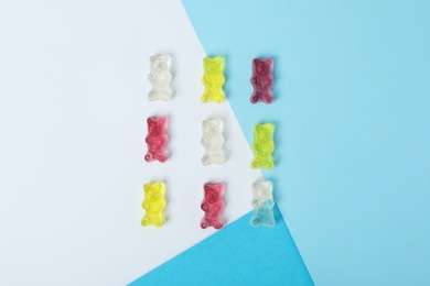 Delicious little jelly bears on color background, flat lay