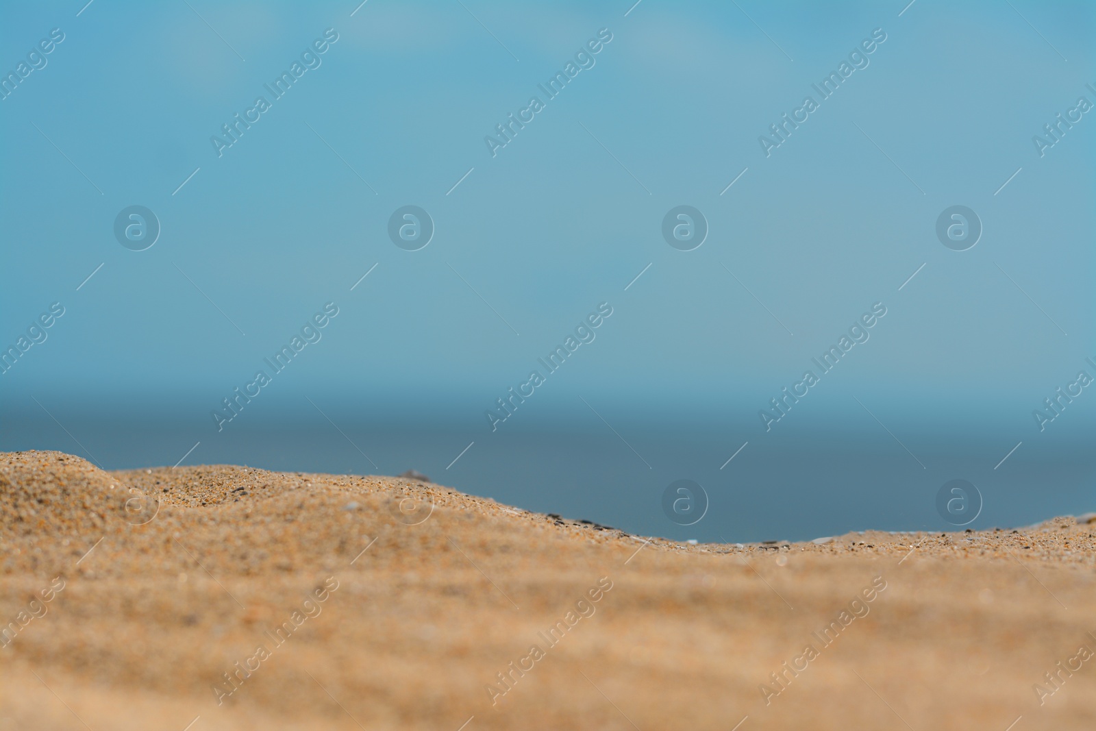 Photo of Closeup view of sandy beach near sea on sunny day