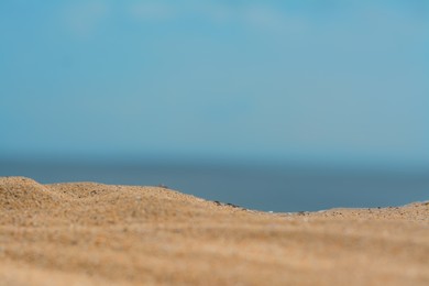 Photo of Closeup view of sandy beach near sea on sunny day