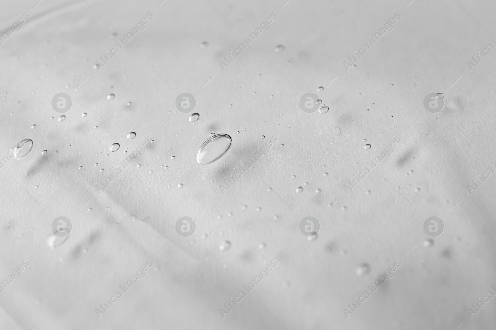 Photo of Texture of transparent shower gel on white background, closeup