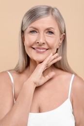 Photo of Portrait of beautiful senior woman on beige background