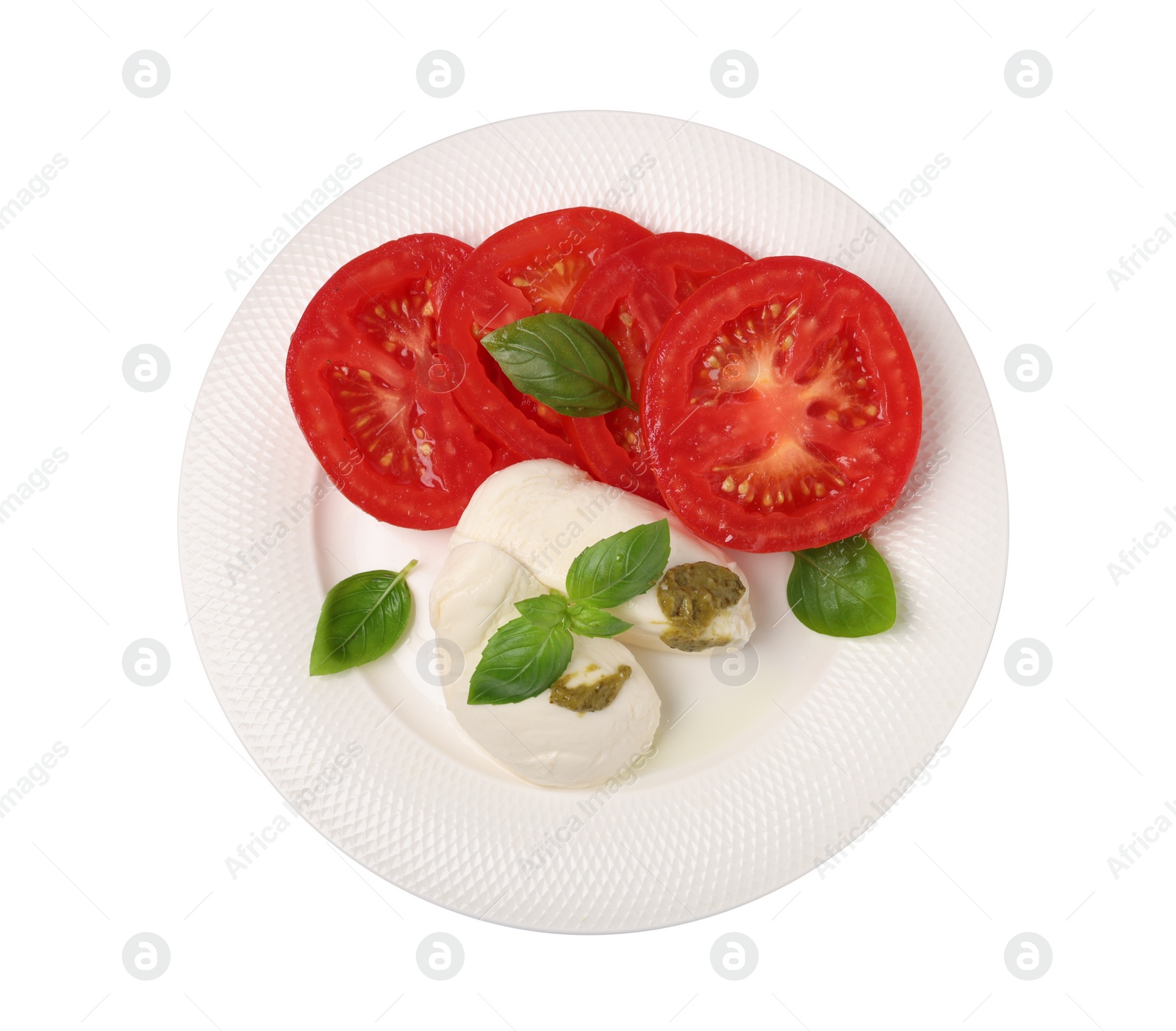 Photo of Plate of tasty Caprese salad with mozzarella, tomatoes, basil and pesto sauce isolated on white, top view