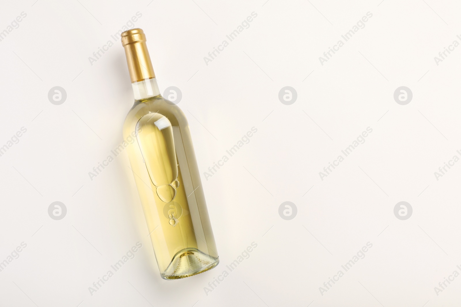 Photo of Bottle of expensive white wine on light background, top view. Space for text