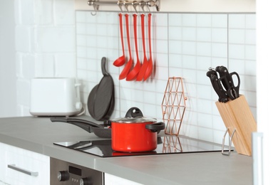 Photo of Clean cookware and utensils on table in kitchen