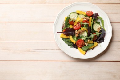 Photo of Tasty fresh vegetarian salad on light wooden table, top view. Space for text