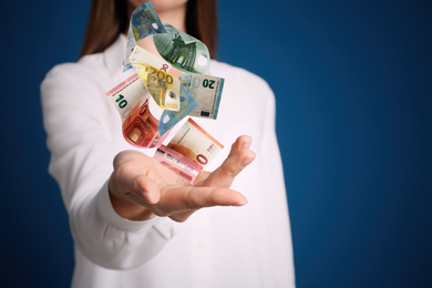 Image of Woman with money on blue background, closeup. Currency exchange