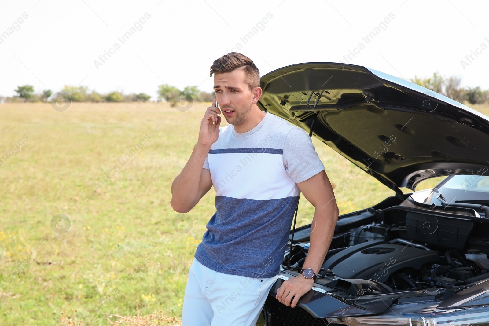 Photo of Man talking on phone near broken car outdoors. Space for text