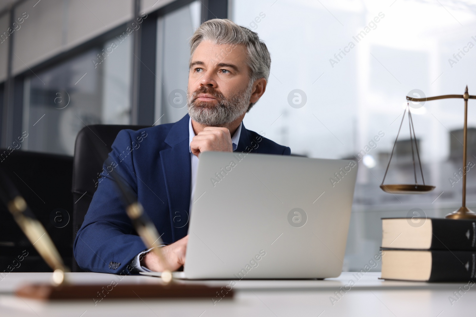 Photo of Handsome lawyer working at table in office