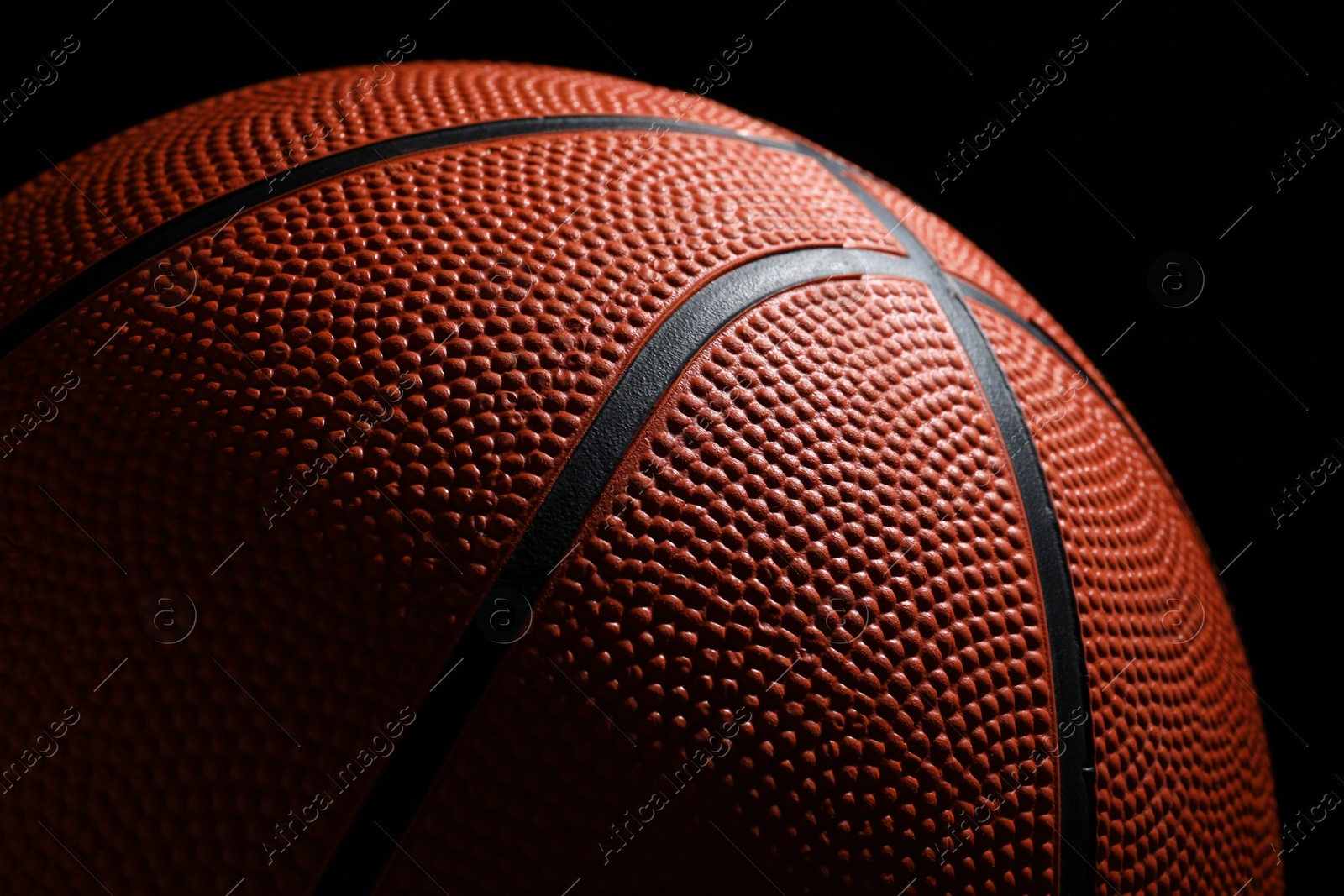 Photo of Orange basketball ball on black background, closeup