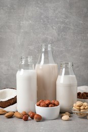 Different nut milks on light grey table