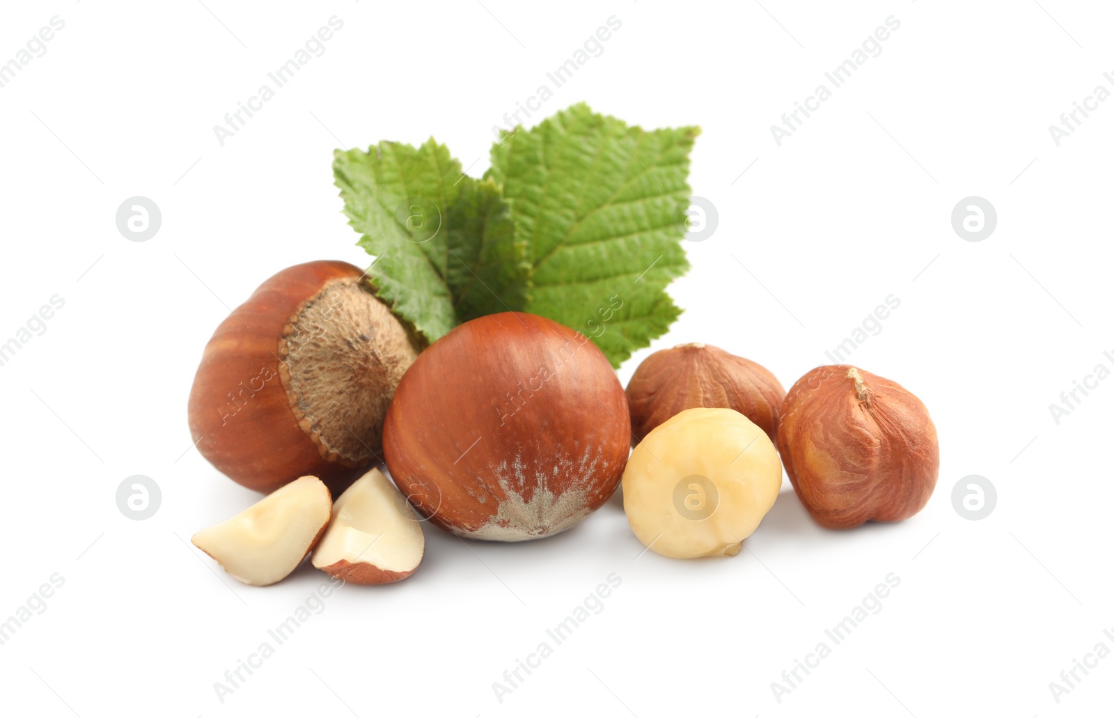 Photo of Tasty organic hazelnuts and leaves on white background