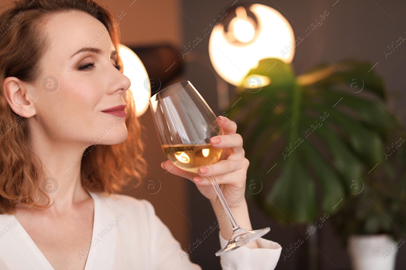 Photo of Woman with glass of delicious wine indoors