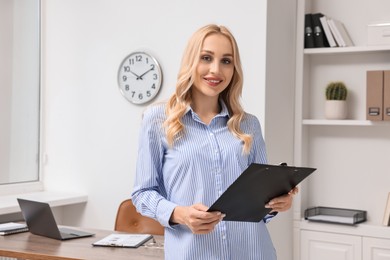 Portrait of happy secretary with clipboard in office