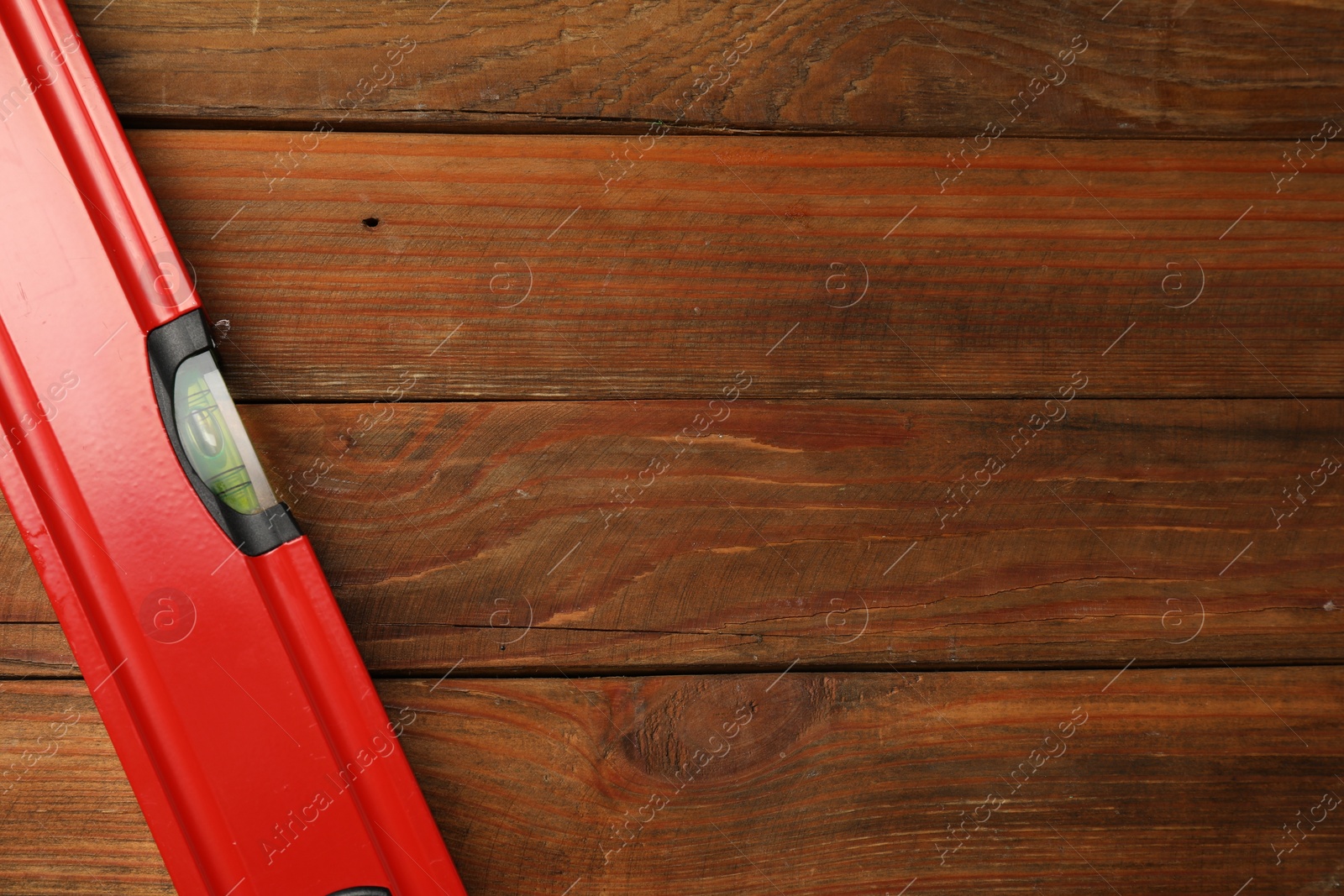 Photo of Building level on wooden table, top view. Space for text