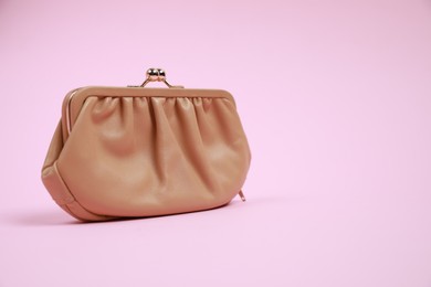 Photo of Stylish beige leather purse on pink background, space for text