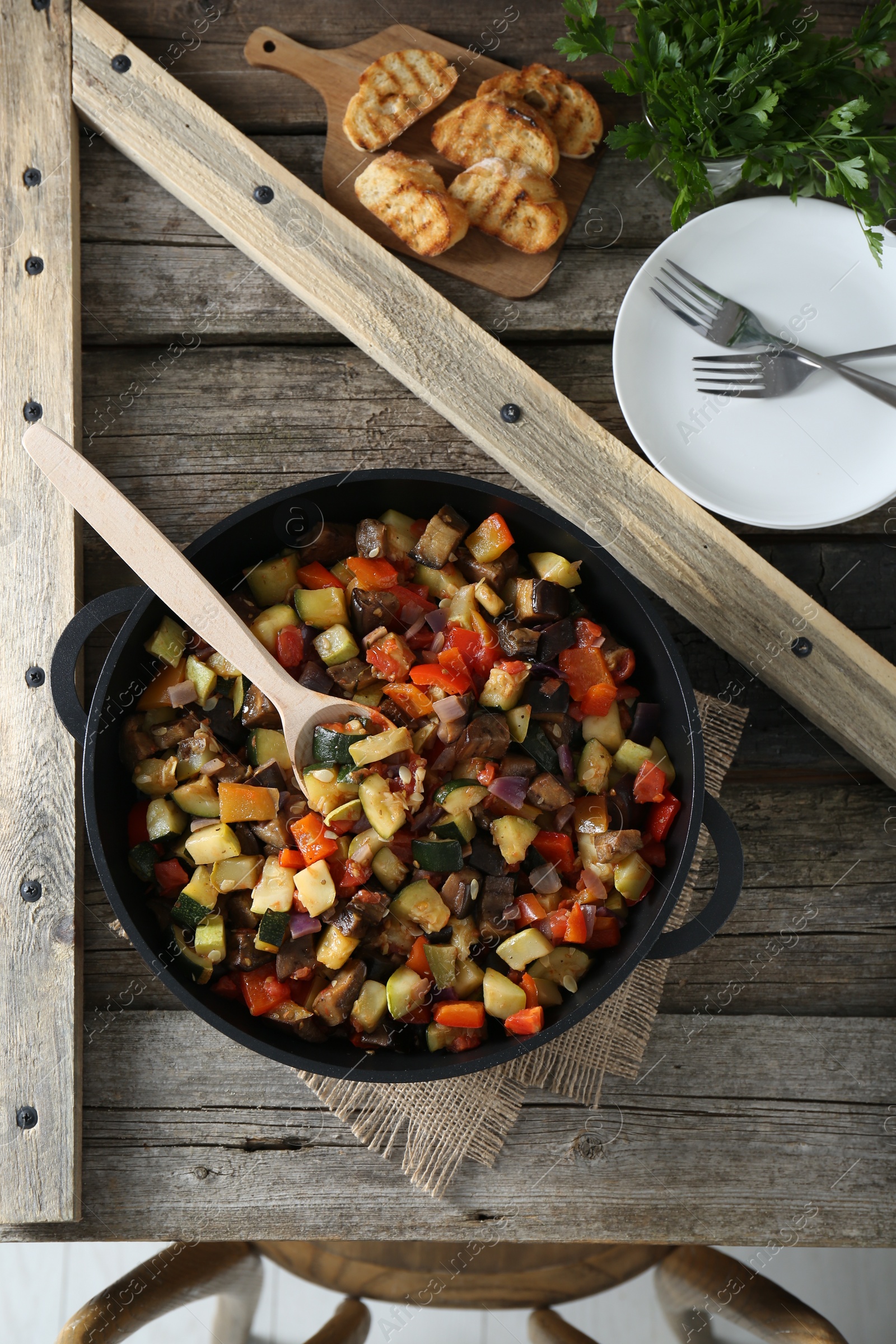 Photo of Delicious ratatouille served on wooden table, flat lay