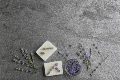 Flat lay composition with hand made soap bars and lavender flowers on grey stone table. Space for text