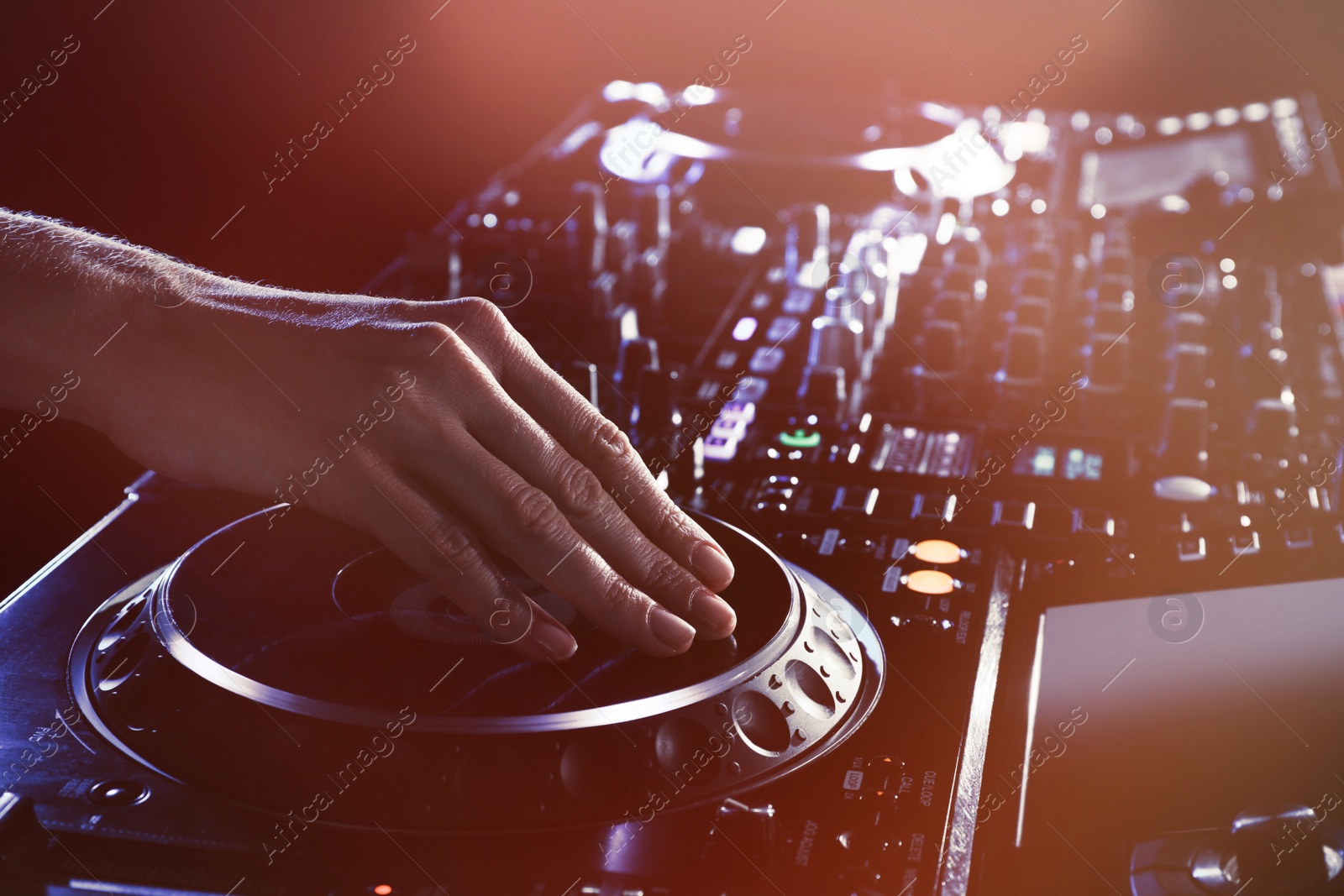 Photo of DJ creating music on modern console mixer in night club, closeup