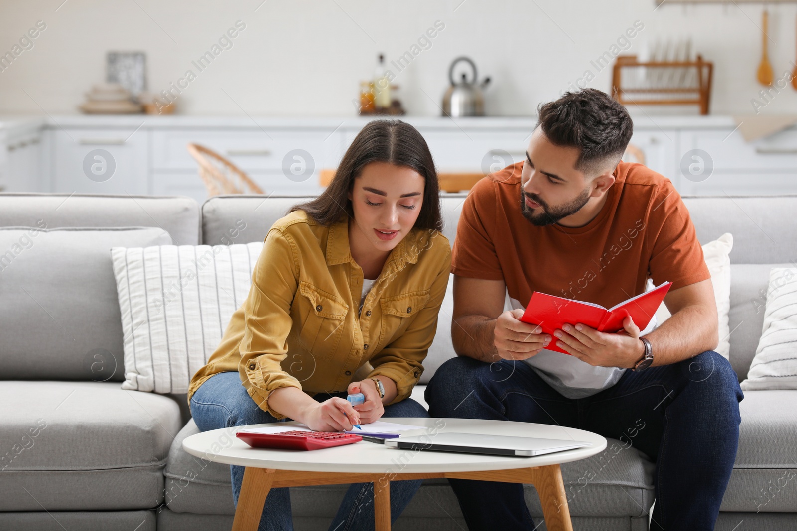 Photo of Young couple discussing family budget at home