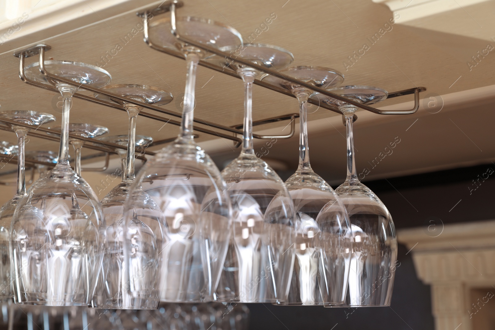 Photo of Set of empty clean glasses on bar racks