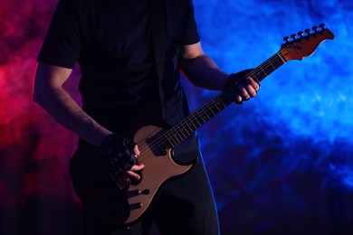 Man playing electric guitar on stage, closeup. Rock music