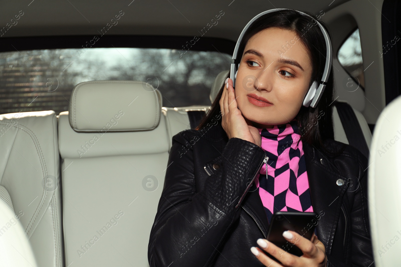 Photo of Young woman listening to audiobook in car