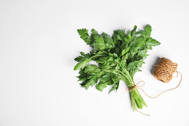 Photo of Bunch of fresh green parsley and twine on white background, top view