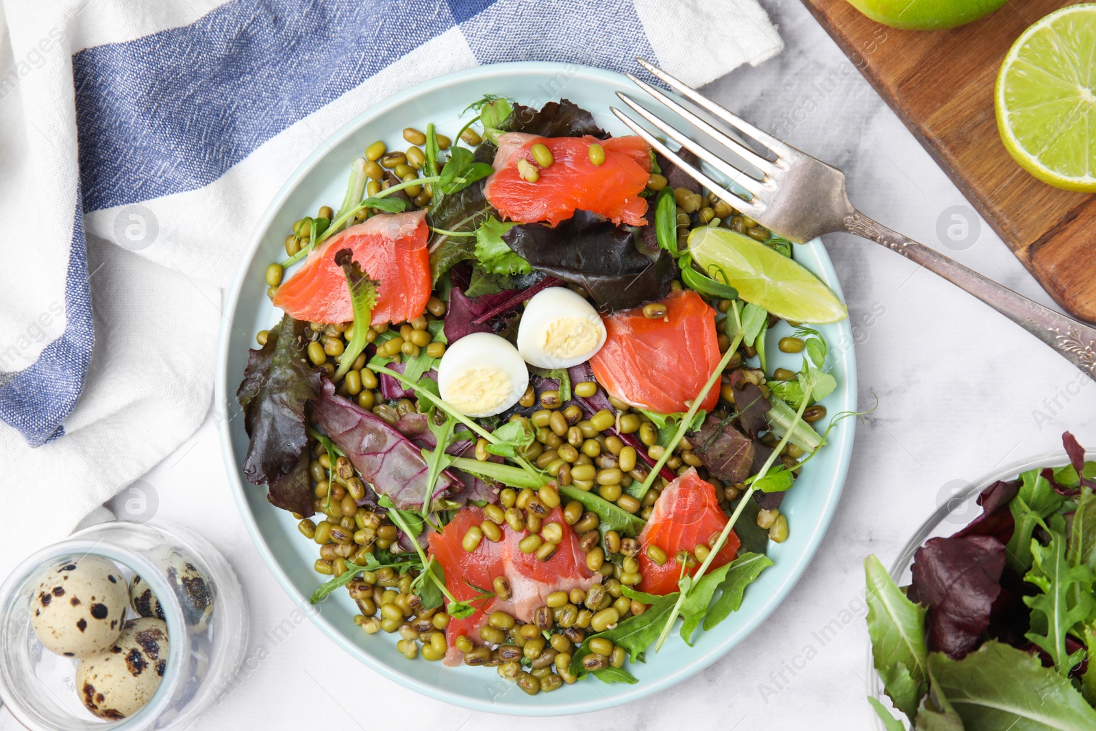 Photo of Plate of salad with mung beans on white marble table, flat lay