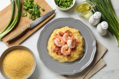 Plate with fresh tasty shrimps, bacon, grits and green onion on white marble table, flat lay