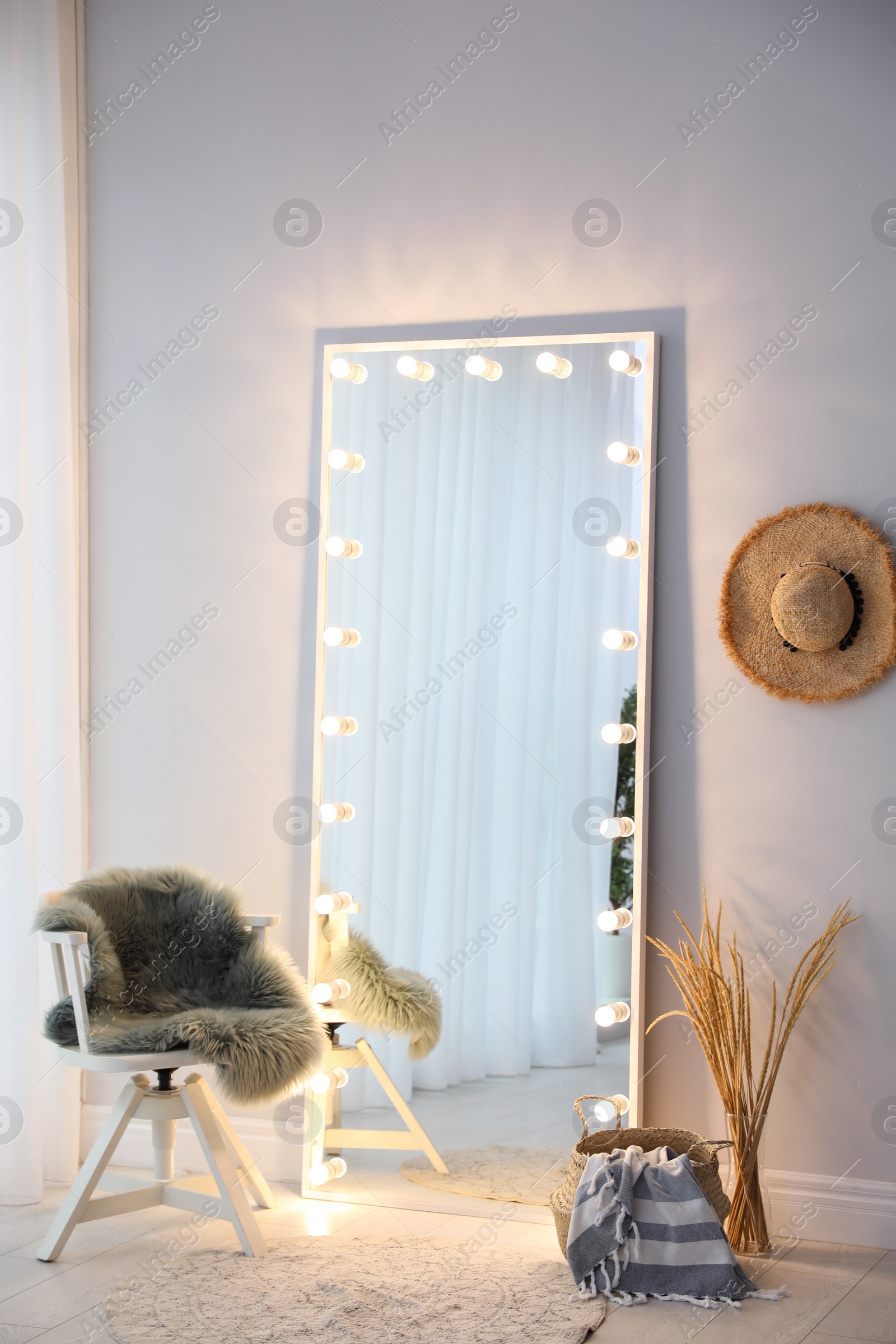 Image of Full length dressing mirror with lamps in stylish room interior