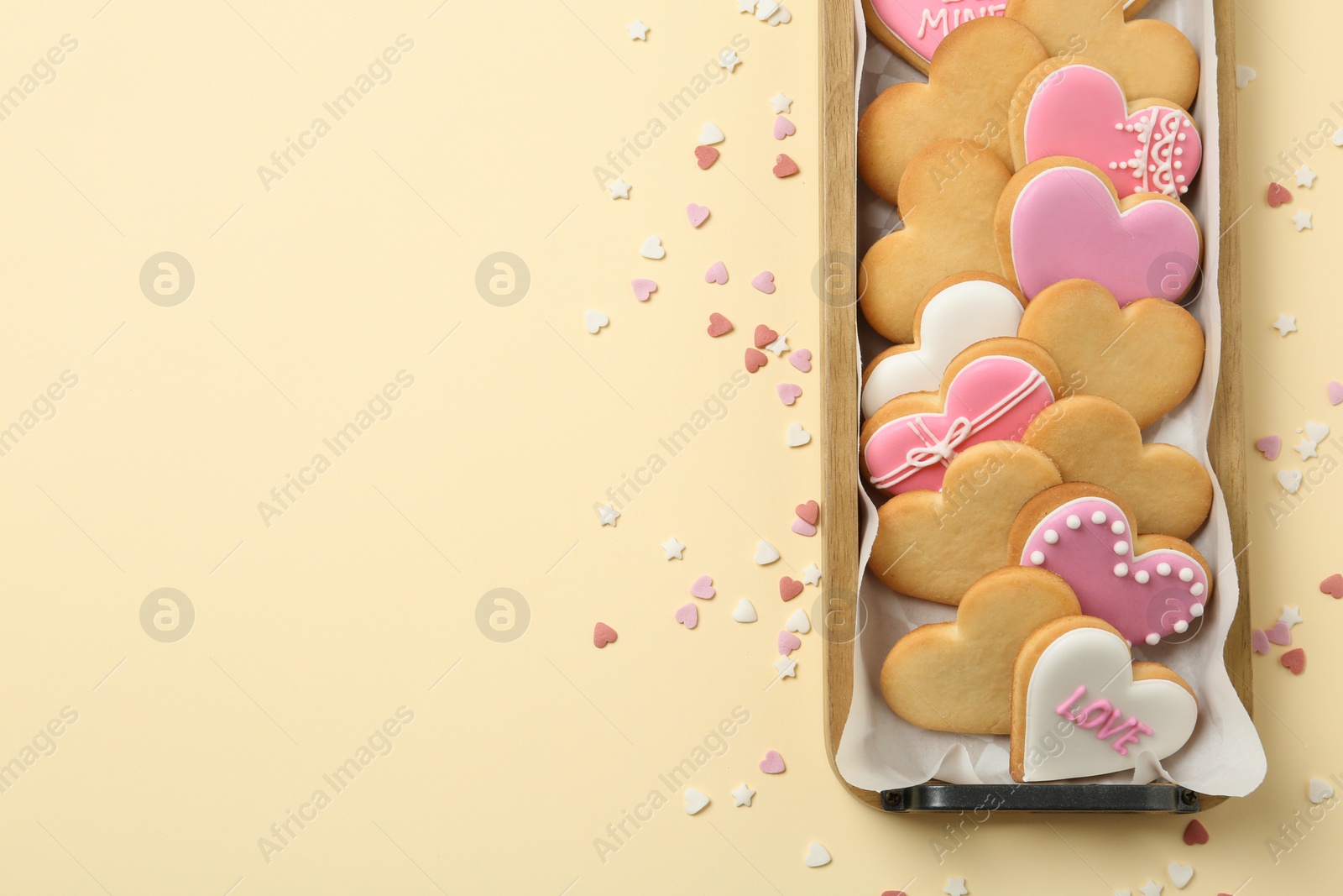 Photo of Tray with decorated heart shaped cookies and space for text on color background, top view