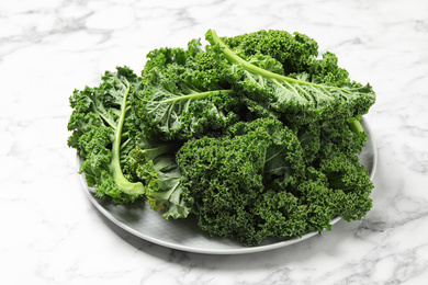 Fresh green kale leaves on white marble table