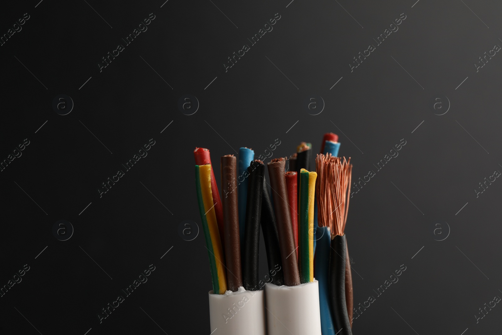 Photo of Cables with electrical wires on black background, closeup