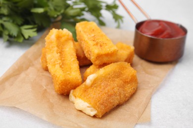 Photo of Tasty fried mozzarella sticks served with ketchup on white table, closeup