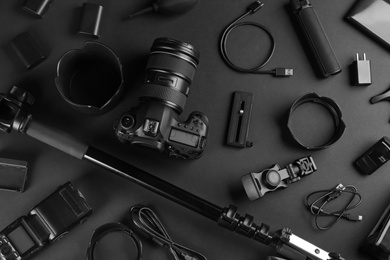 Flat lay composition with camera and video production equipment on black background