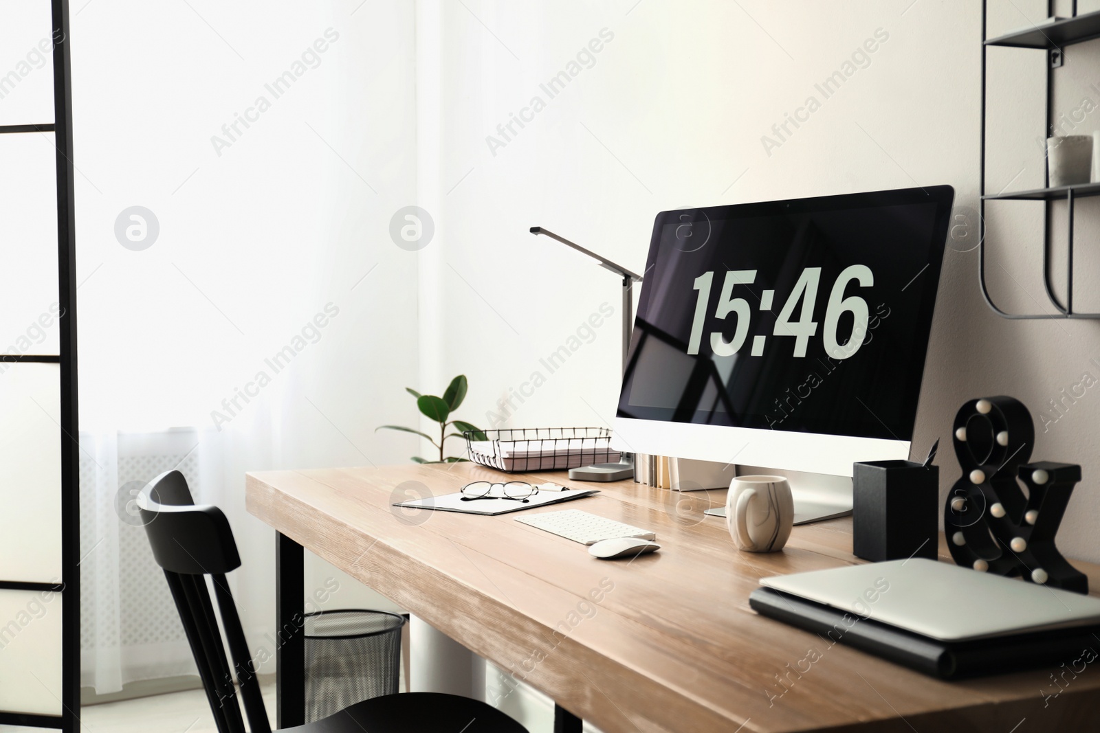 Photo of Modern workplace with computer in room. Interior design